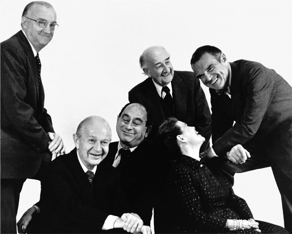 Sort-hvidt fotografi af Herman Millers grundlægger D.J. De Pree sammen med designchef George Nelson og de designere, de ansatte: Robert Propst, Alexander Girard og Ray og Charles Eames.