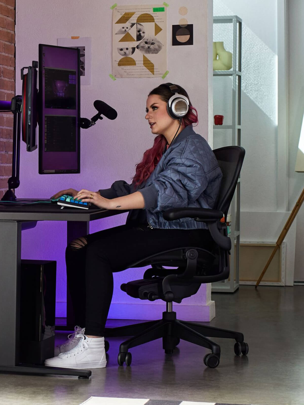 Electra spiller på Aeron i onyx sort med Nevi-gamingbord i sort og Ollin-skærmarm