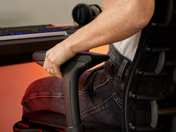 Nærbillede af Dr. Lindsey Migliore, der justerer armen på Embody gaming-stol