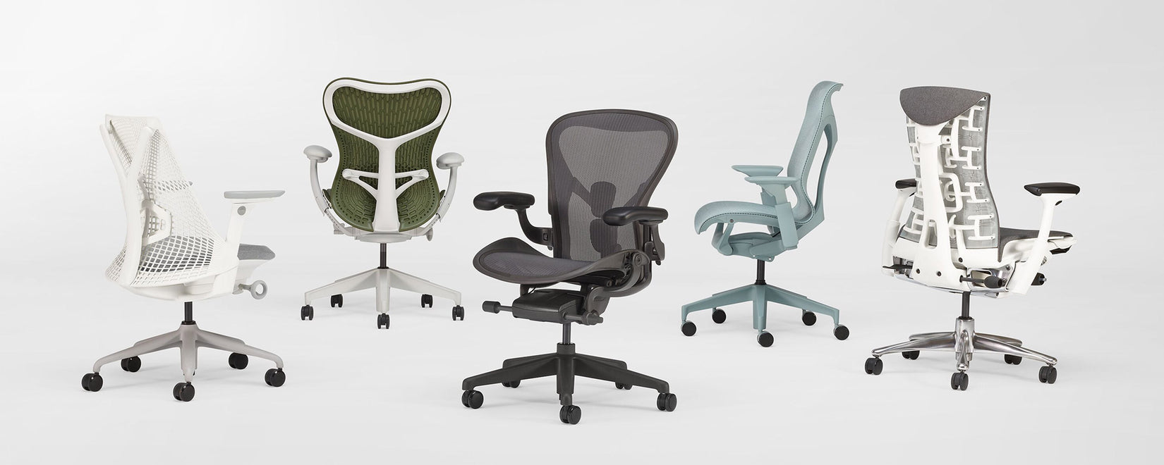En række med 5 ergonomiske kontorstole fra Herman Miller i et hvidt studie. Herunder Sayl, Mirra 2, Aeron, Cosm og Embody.