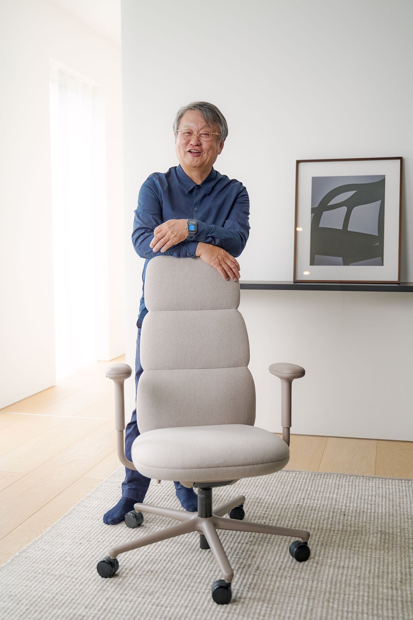 Fotografi af Naoto Fukasawa stående bag en Asari-kontorstol i alpin hvid