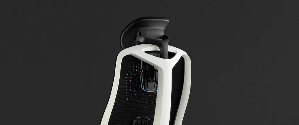 Bagfra af en hvid og sort Vantum-gamingstol fra Herman Miller, overlejret med hvid grafik, der fremhæver rygstøtten og nakkestøtten.
