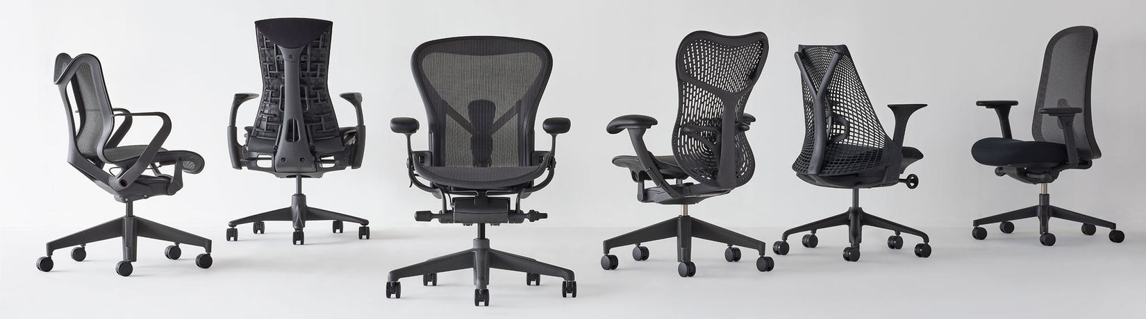 Række af Herman Miller-kontorstole til hjemmet i forskellige vinkler, alle i grafit, med Cosm med lav ryg, Aeron, Mirra 2 og Lino