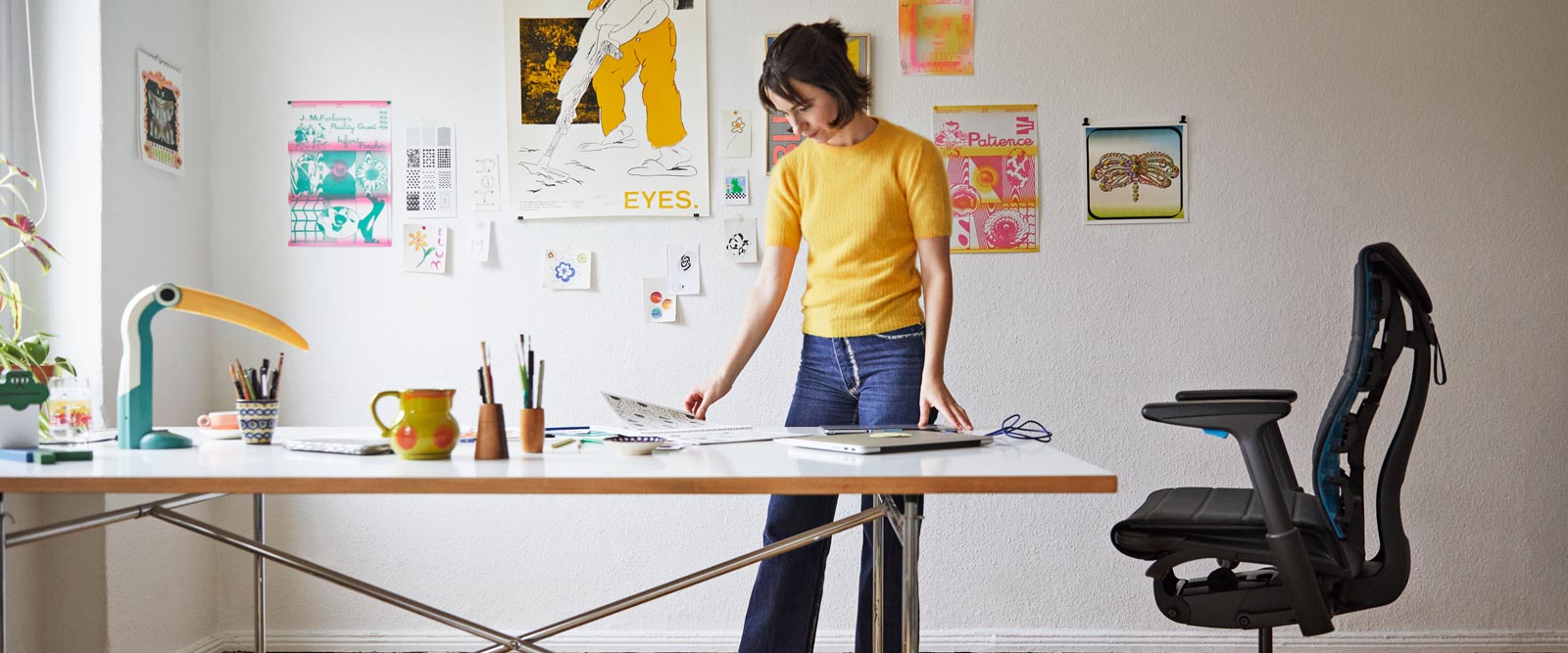 Illustrator, maler og forfatter Molly Rose Dyson stod i sit atelier med en Embody-gamingstol i sort og cyanblå