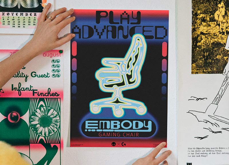 Billede af den endelige plakat for Embody gaming-stolen holdt op mod væggen af Molly Rose Dyson