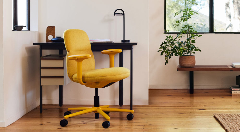 En gul Asari-kontorstol fra Herman Miller, betrukket med Clarion Luce-stof fra Maharam - med et Mode-skrivebord og en Marselis-lampe.