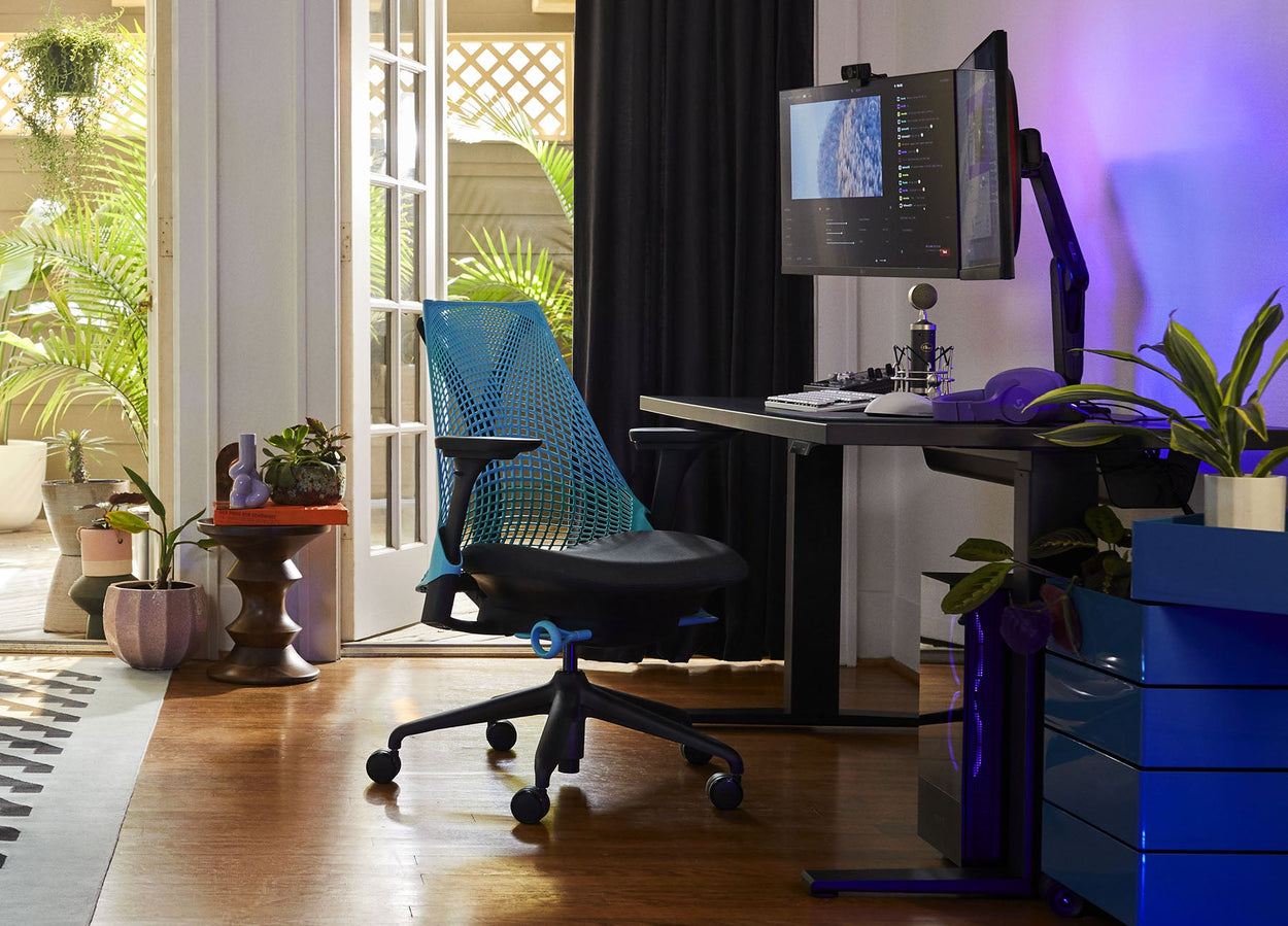 Foto af Friskks gaming-opsætning derhjemme bestående af Sayl-gamingstol i sort og havblå med Nevi-gamingbord i sort