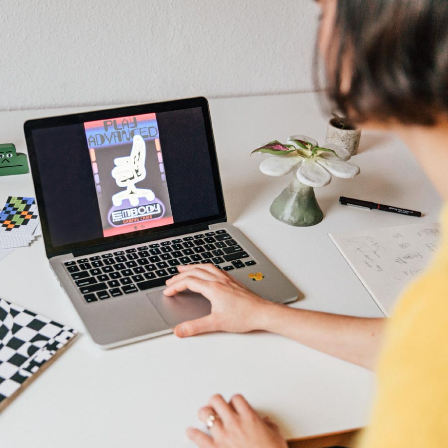 Designer Molly Rose Dyson arbejder på en Herman Miller Embody-plakat på en bærbar computer