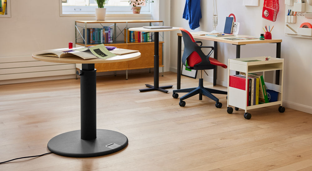 Et farverigt hjemmekontor med et sort og asketræ OE1 stående skrivebord fra Herman Miller, et Passport arbejdsbord, et OE1 skrivebord, en sort og rød Zeph stol og en hvid OE1 trolley.
