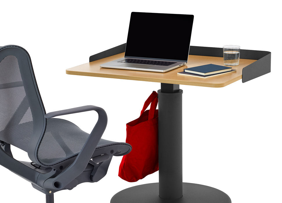 En blå Cosm-kontorstol fra Herman Miller, placeret foran et sort og askegråt OE1-stående skrivebord fra Herman Miller, med en valgfri omsluttende skærm.