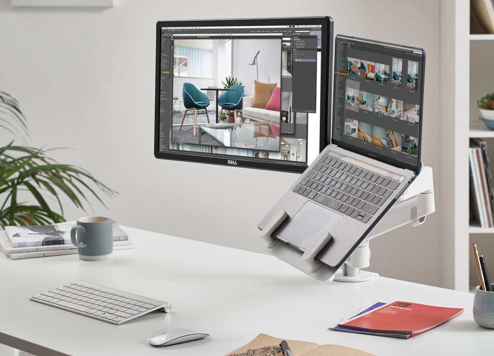 En hvid Lima dobbelt monitorarm fra CBS med en hvid laptopholder, der viser computerskærmen og laptopholderen.