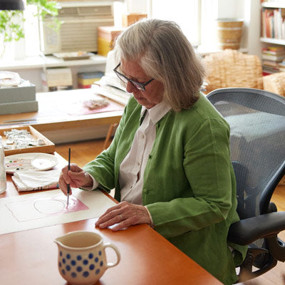 Illustrator, maler og forfatter sidder og maler i en Herman Miller Aeron-kontorstol i grafit