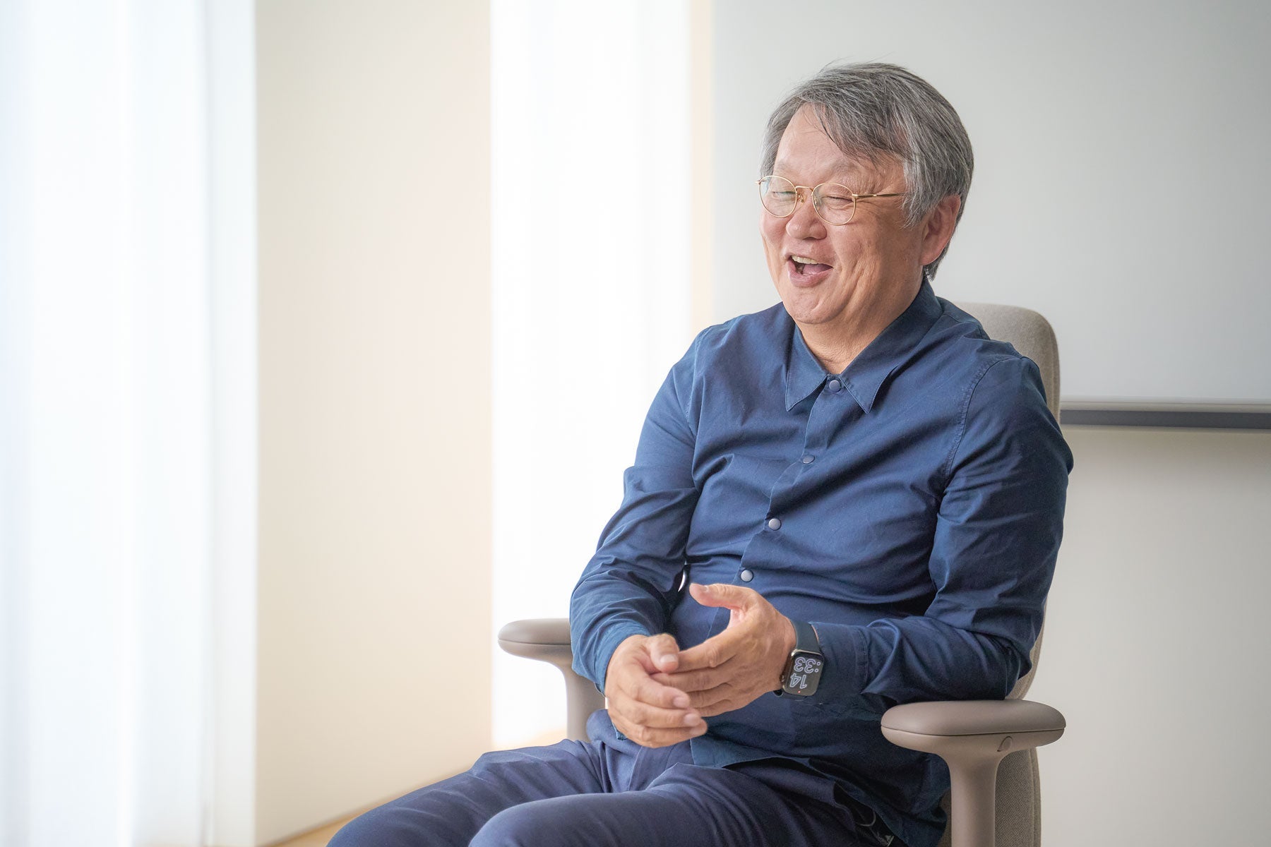 Muntert fotografi af Naoto Fukasawa siddende i en Asari-kontorstol