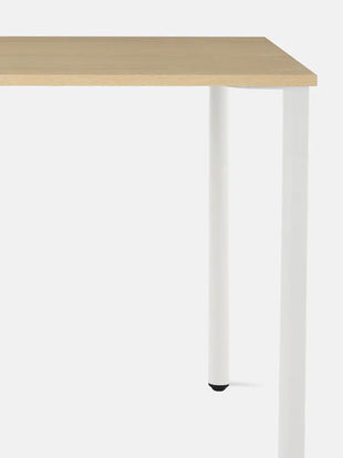 Nærbillede forfra af et hvidt og asketræs OE1-skrivebord fra Herman Miller, der viser den holdbare og rengøringsvenlige bordplade.