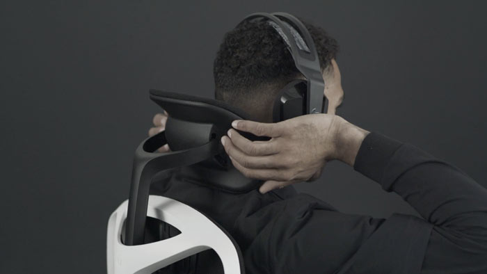 En video af en person, der sidder i en hvid og sort Vantum-gamingstol fra Herman Miller og rækker om bag stolen for at justere nakkestøtten.