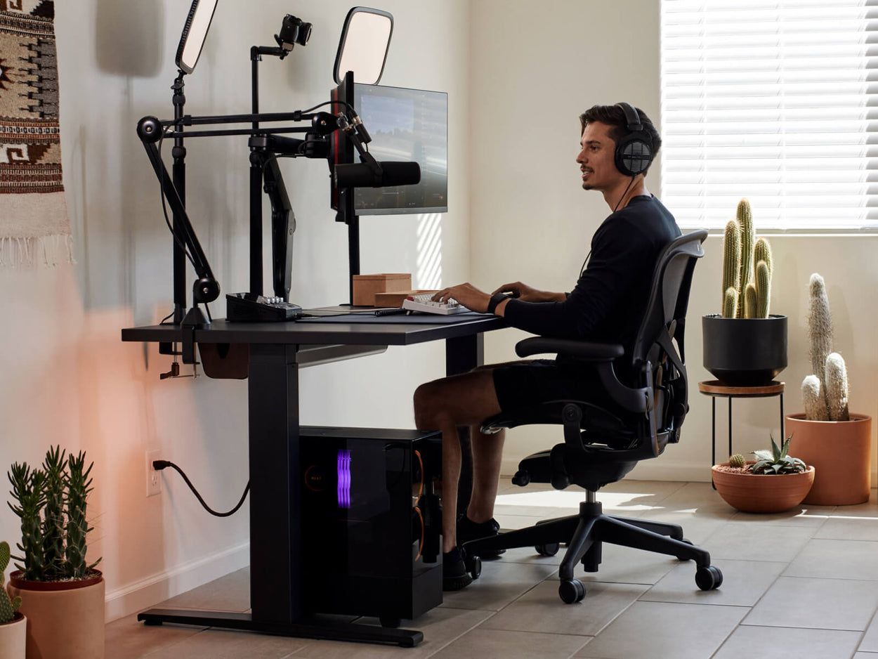 Gamer Xaryu spiller spil på sin Herman Miller-opsætning i Aeron-gamingstol med Nevi-gamingbord og Ollin-dobbeltmonitorarme